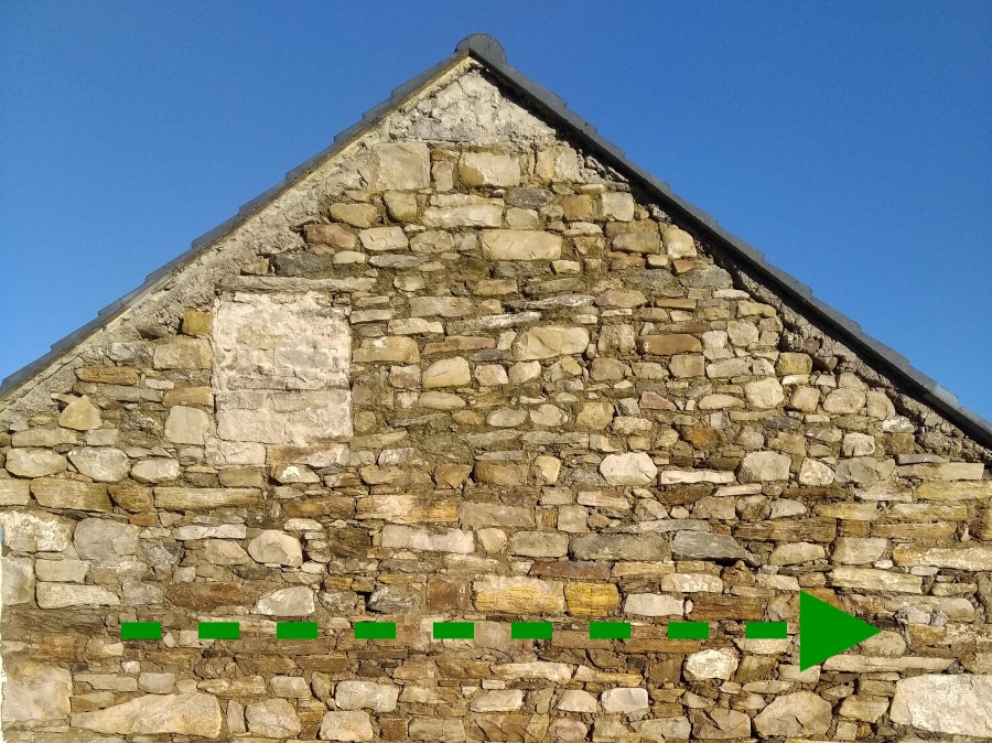 Picture of gable of Bernd Wortmann's cottage during renovation with green dotted arrow